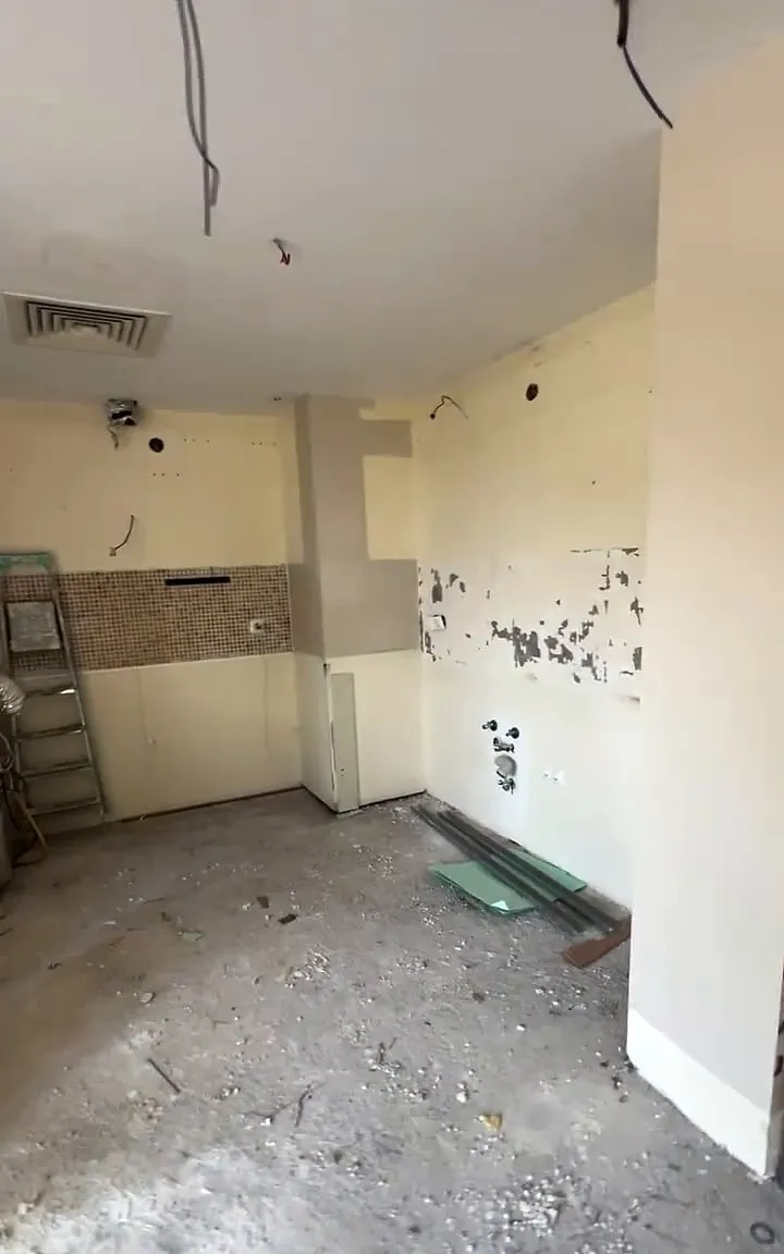Öncesi: aynı mutfak köşesi; sökülmüş duvarlar, dökülen boya, açıkta borular ve yerde moloz
